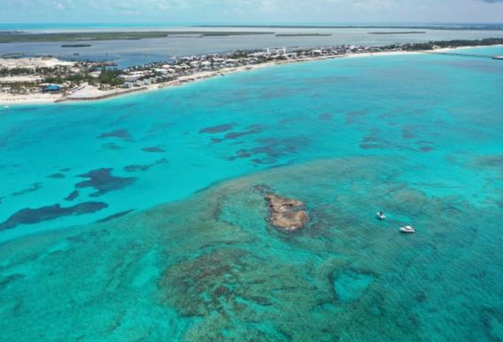 Aerial view of turquoise Bimini water, reefs and the narrow island strip
